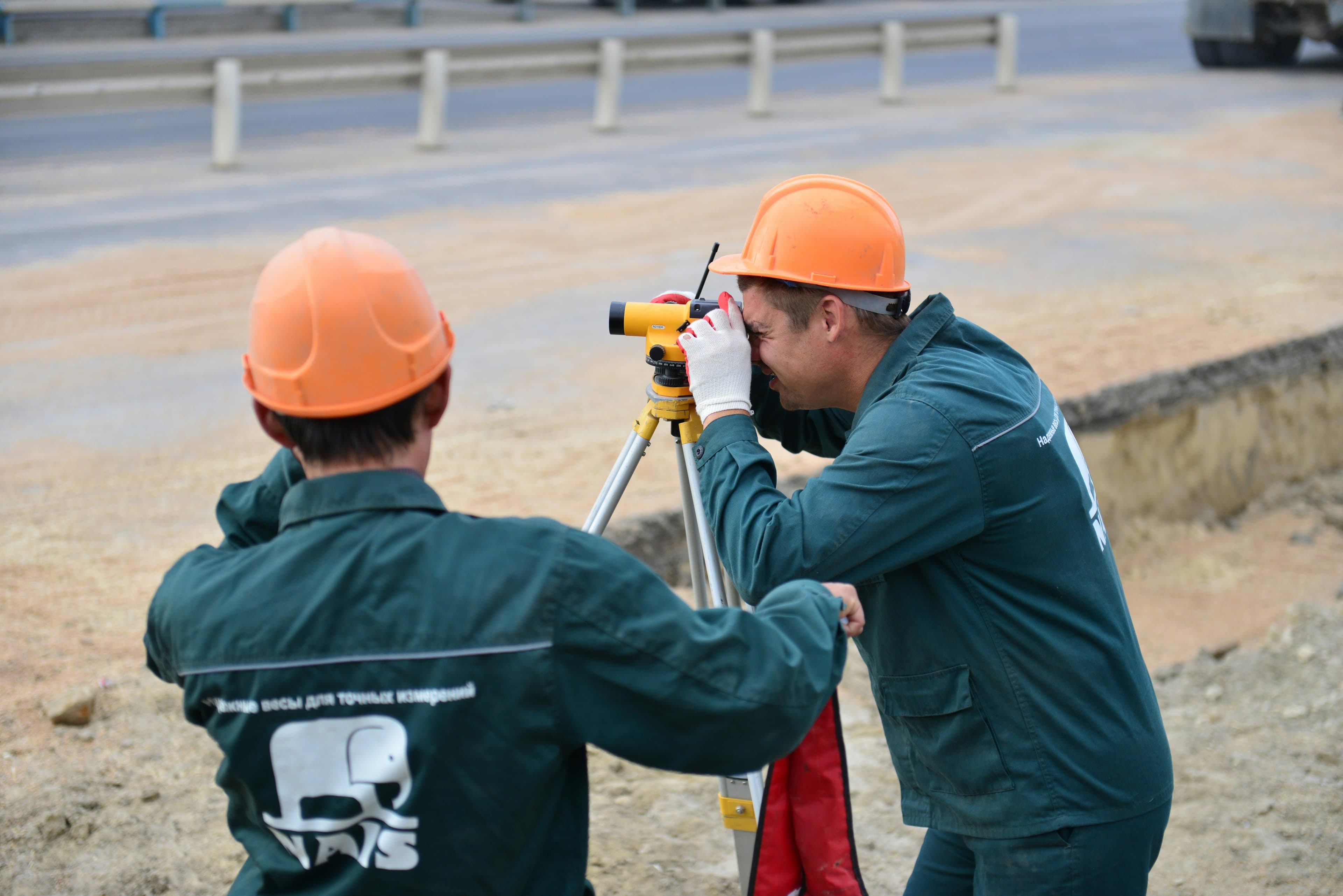 Environmental consultant conducting a site inspection with industrial infrastructure in the background